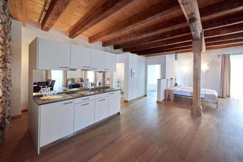 a kitchen with white cabinets and a bed in a room at Hotel Restaurant Rathaus in Thun