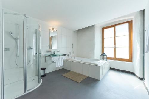ein Bad mit einer Badewanne, einer Dusche und einem Waschbecken in der Unterkunft Hotel Restaurant Rathaus in Thun