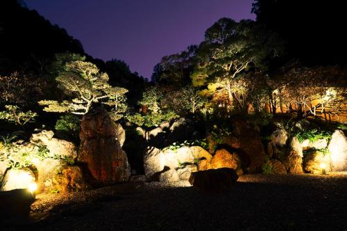 a garden with rocks and trees at night at 高野山 宿坊 不動院 -Koyasan Shukubo Fudoin- in Koyasan