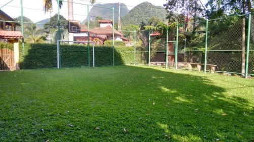 a fenced in yard with a basketball hoop at Casa Temporada em Lumiar in Lumiar