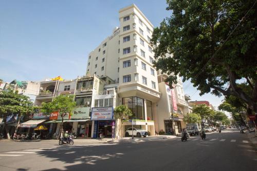 a tall white building on a city street at Central Hotel & Spa Danang in Da Nang