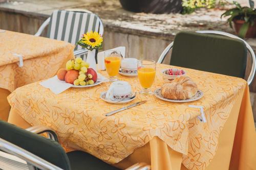 a table with plates of food and glasses of orange juice at Hotel Del Fiume in Cannobio