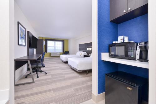 a hotel room with a bed and a desk with a microwave at Holiday Inn Express Mystic, an IHG Hotel in Mystic