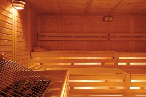 a sauna with three beds in a wooden cabin at Pension Bergland in Lech am Arlberg