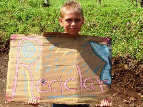 a young boy holding a sign that says everyday at Vocaré Finca Agroecológica in Upala