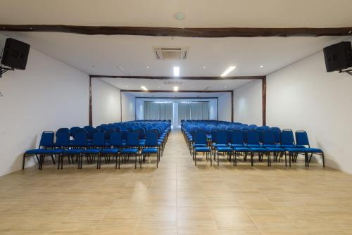 an empty room with blue chairs in a building at Tree Bies Resort - Oficial in Subaúma