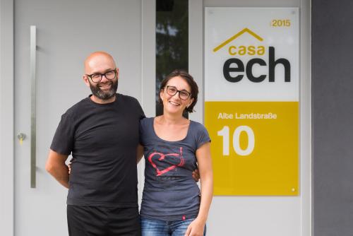 un homme et une femme debout devant un panneau dans l'établissement Casa ECH, à Gerbrunn