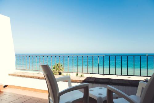 Un balcón con sillas y vistas al océano. en Hotel Miramar Badalona, en Badalona