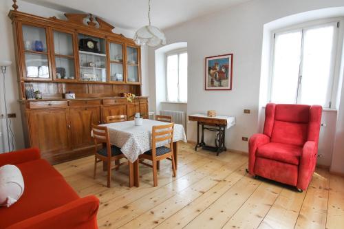 Casa da Aldo في Castelfondo: غرفة معيشة مع طاولة وكرسي احمر