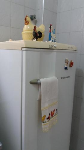 a white refrigerator with toys on top of it at Apartamento Aconchego da vovó in Peruíbe