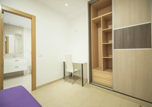 1 dormitorio con escritorio, silla y espejo en EnjoyGranada GRAN VIA B-A & Parking opcional, en Granada