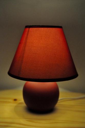 a red lamp sitting on top of a table at Rooms LU&LA in Velika Gorica