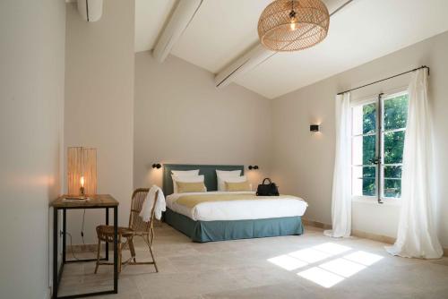 a bedroom with a bed and a table and a window at Domaine de Saint Clair in Aix-en-Provence