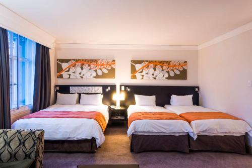 a hotel room with two beds and a window at ONOMO Hotel Cape Town – Inn On The Square in Cape Town