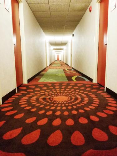 a long hallway with a large rug on the floor at Ramada by Wyndham Alpena in Alpena