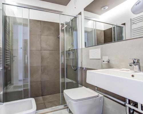 a bathroom with a toilet and a sink and a shower at Hotel Villa Augustea in Rimini