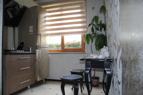 a kitchen with a table and two stools and a window at Apartment Olivia in Kursk