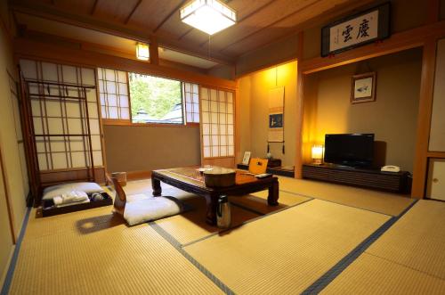 a living room with a table and a tv at 高野山 宿坊 不動院 -Koyasan Shukubo Fudoin- in Koyasan