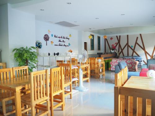 Le Lerts Living Hotel في كون كاين: غرفة طعام مع طاولات وكراسي خشبية