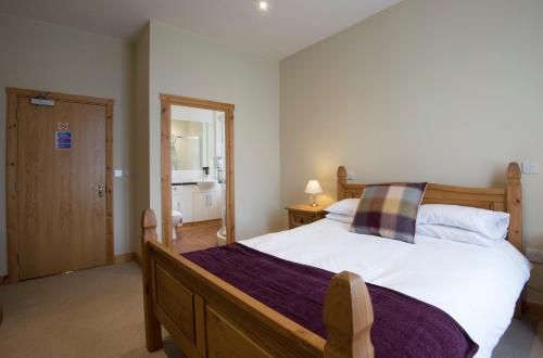 a bedroom with a large bed and a mirror at The Mount B&B in Malton