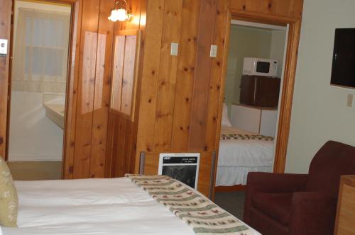 a room with a bed and a living room with a microwave at Trees Motel in Bishop