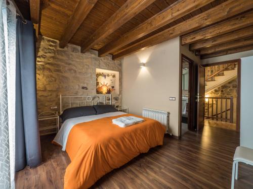 ein Schlafzimmer mit einem Bett mit einer orangefarbenen Decke in der Unterkunft Casa rural Lo Niu in Caseras