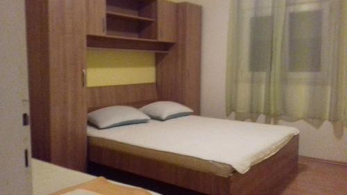 a bedroom with a bed with a wooden headboard at Sanja in Gdinj