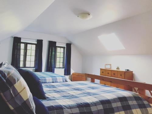 1 dormitorio con 1 cama y 2 ventanas en Chalet Rustique CRDS Tremblant, en Lac-Supérieur