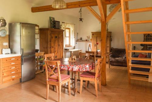 eine Küche mit einem Tisch mit Stühlen und einem Kühlschrank in der Unterkunft Outline chata Svetla in Hartmanice