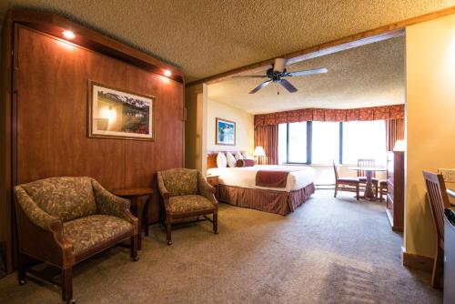 a hotel room with a bed and two chairs at The Grand Lodge Hotel and Suites in Mount Crested Butte