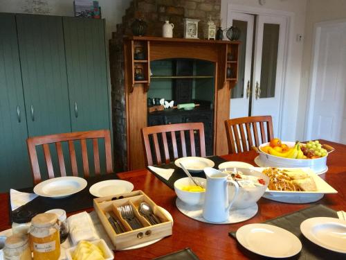 una mesa de madera con comida encima en Chelsea House Bed & Breakfast, en Whangarei