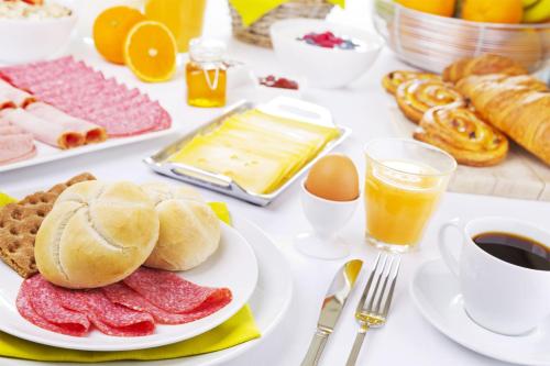 una mesa con productos para el desayuno, café y huevos en Palmeras Beach Hotel, en Punta del Este