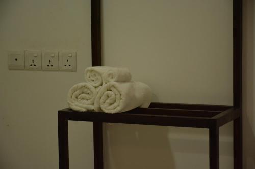 a pile of towels sitting on a shelf in a bathroom at Seasons Villa in Dambulla