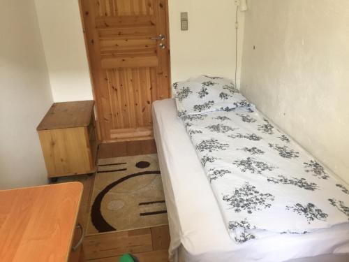 a small bedroom with a bed and a wooden table at Rosenlund Bed & Breakfast in Skovsgårde