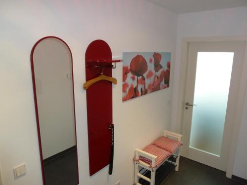 a room with a red mirror and a chair at Schnieke Hüsing in Wismar