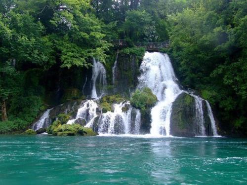 a waterfall in the middle of a body of water at Viola i Detelina Apartments in Perućac