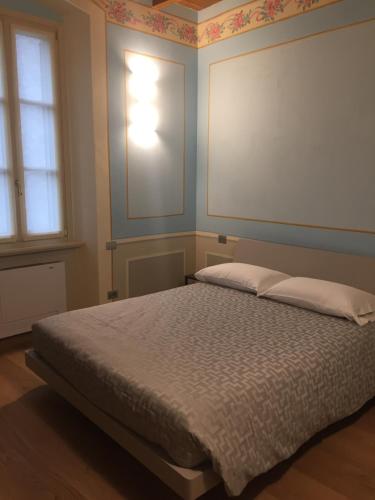 a bedroom with a bed with a white bedspread at Palazzo Carasi Apartments in Cremona