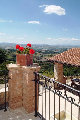 a planter with red flowers on top of a balcony at San Giovanni al Monte in Collazzone