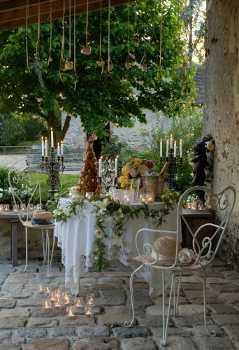 a table with candles and a table with chairs at Le Moulin Bregeon in Linières-Bouton