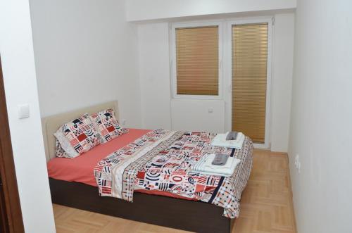 a small bedroom with a bed with a red blanket at Novi Apartman in Strumica