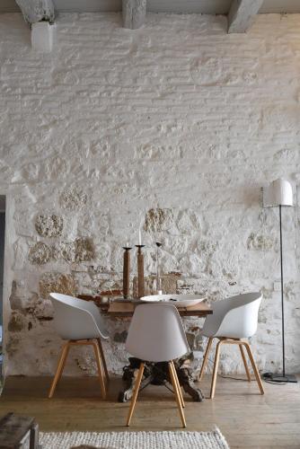 a dining room with a table and two chairs at La maison sur la place in Penne-dʼAgenais