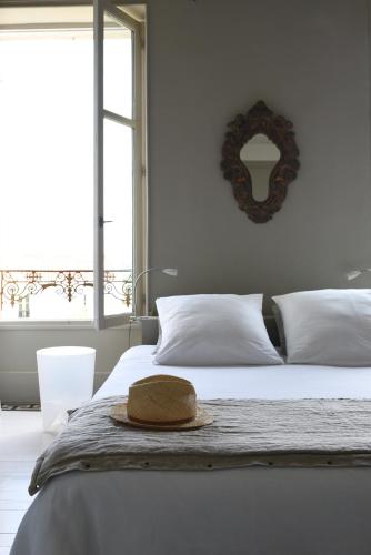 a bedroom with a bed with a hat on it at La maison sur la place in Penne-dʼAgenais