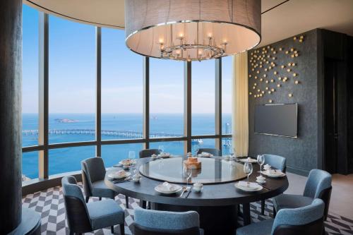 a dining room table with chairs and a large window at Grand Hyatt Dalian in Dalian