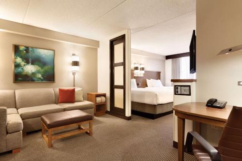Hyatt Place Atlanta/Cobb Galleria في أتلانتا: غرفة في الفندق مع أريكة وسرير