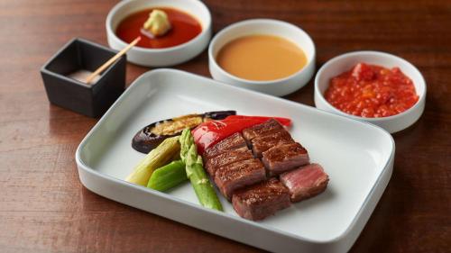 a plate of food with meat and vegetables and sauce at Grand Hyatt Tokyo in Tokyo