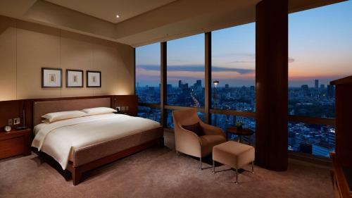 a bedroom with a bed and a view of a city at Grand Hyatt Tokyo in Tokyo