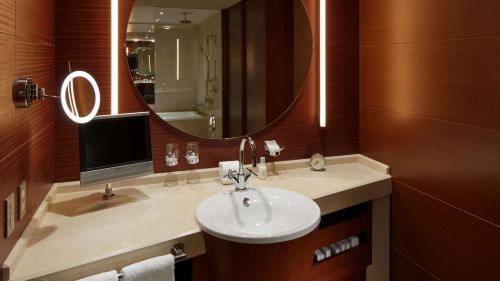 a bathroom with a sink and a mirror and a television at Grand Hyatt Tokyo in Tokyo