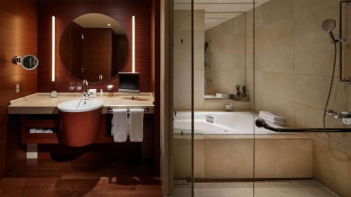 a bathroom with a sink and a tub and a shower at Grand Hyatt Tokyo in Tokyo