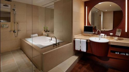 a bathroom with a tub and a sink and a mirror at Grand Hyatt Tokyo in Tokyo