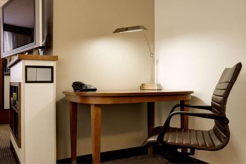 a desk in a room with a lamp and a chair at Hyatt Place Raleigh Durham Airport in Morrisville